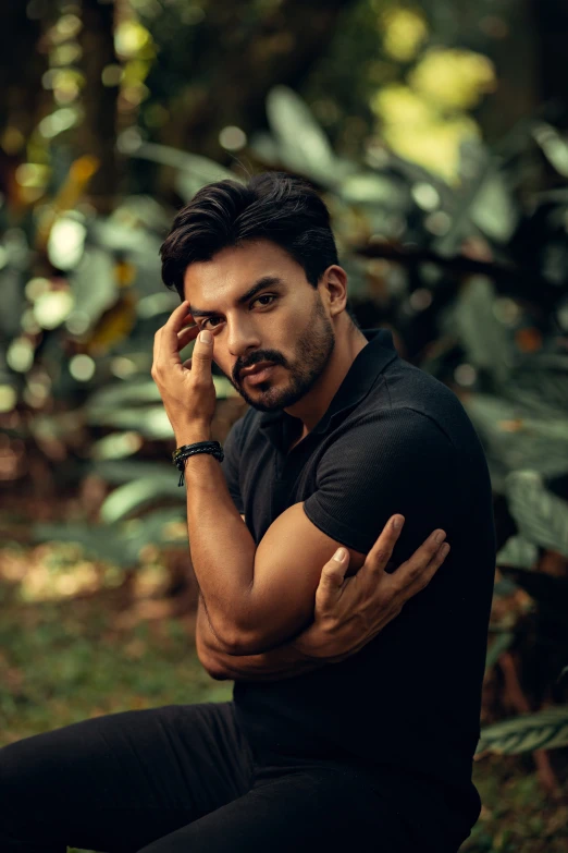 a man sits with his hand to his face