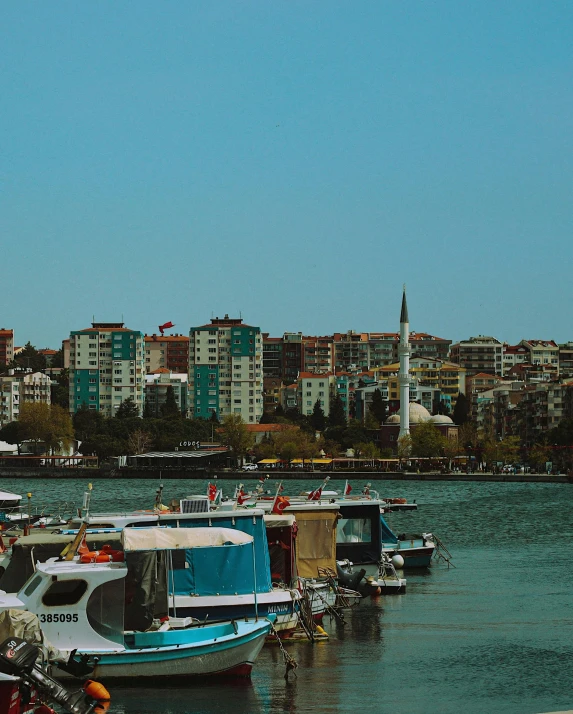 several motor boats docked in the water near some buildings