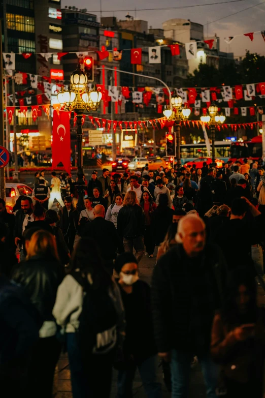 crowd walking on the street under bright red lights