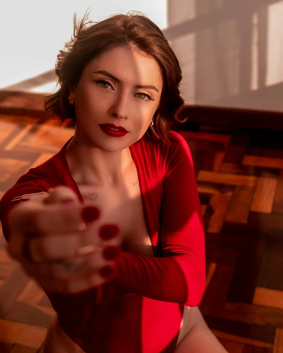 a woman wearing red is pointing her gun