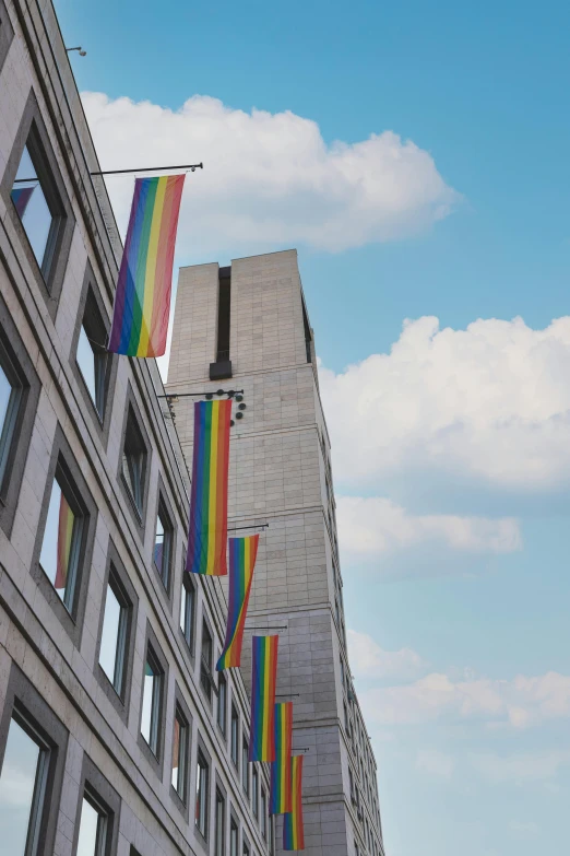 a building with some rainbow flags hanging from it's side