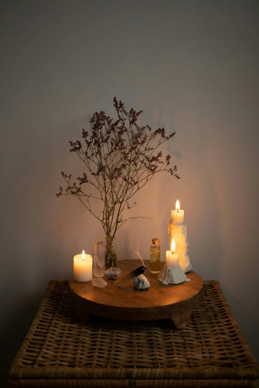 a round wooden table topped with candles and vases