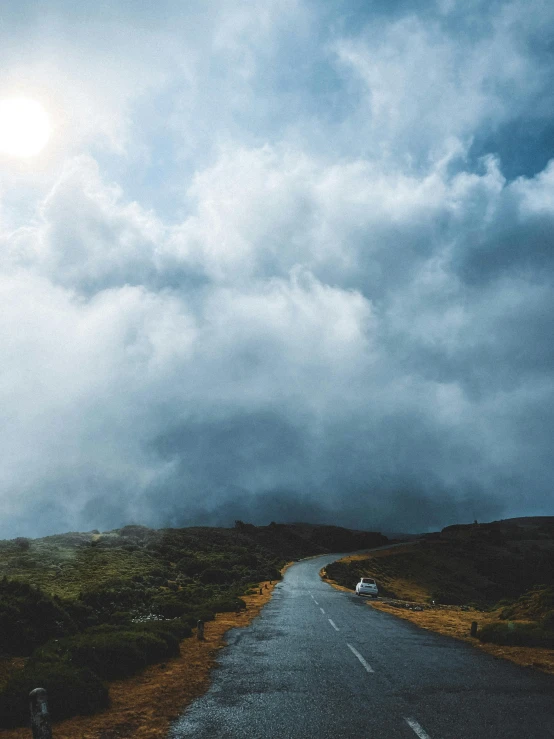 an empty road beneath a sky filled with dark clouds