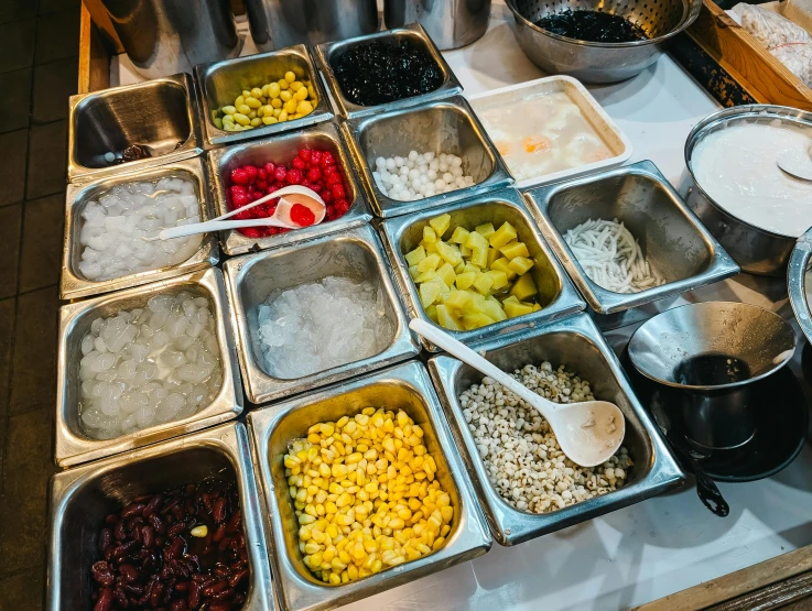 trays filled with different kinds of food sit on a table