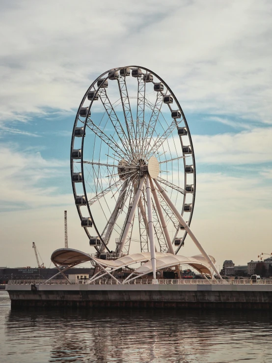 an outdoor ferris wheel next to a pier