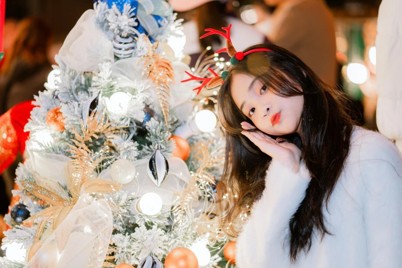 a young woman dressed as a fairy in front of christmas tree