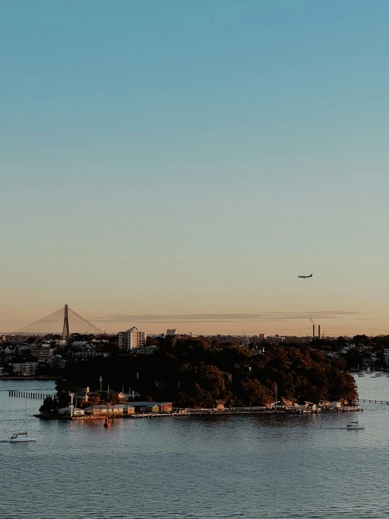 a plane flying over an island with boats