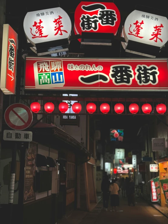 several lit up red signs hang from the ceiling