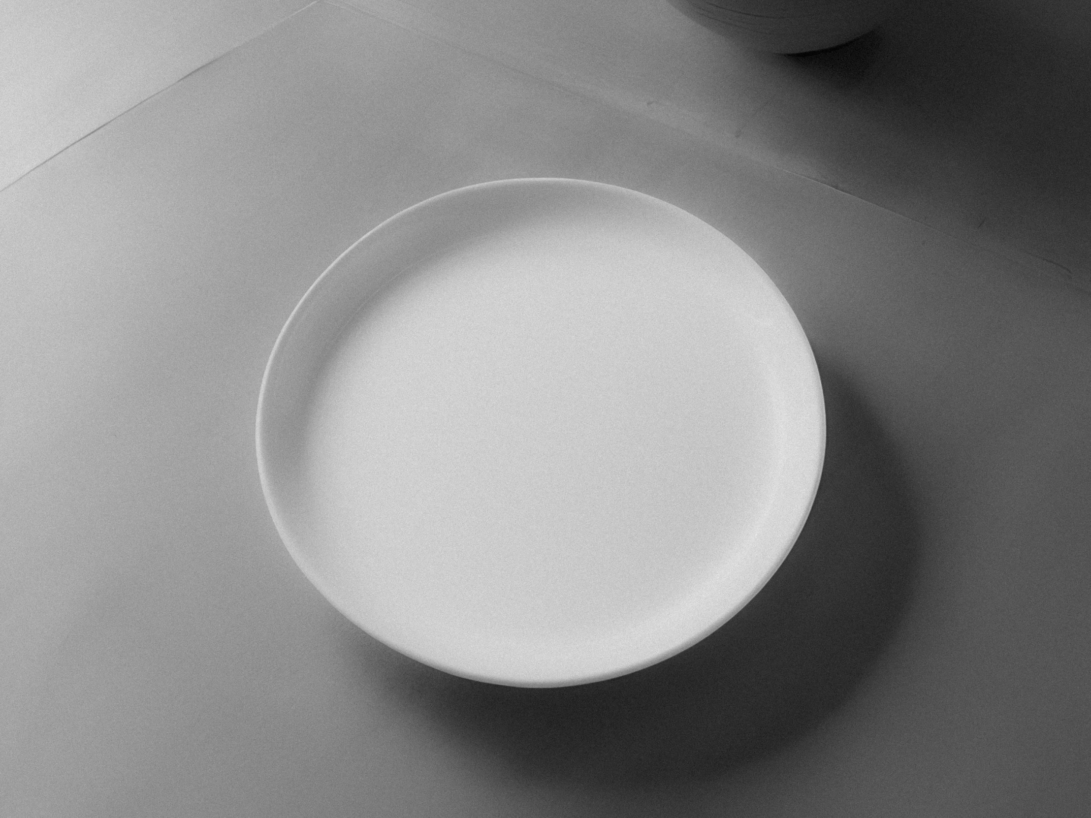 a round white plate and two cups on a table