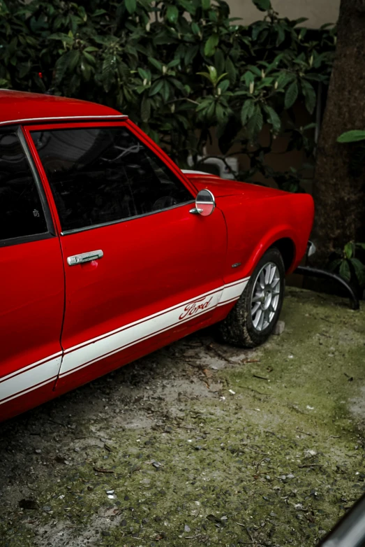 a red car sits parked on the side of the road