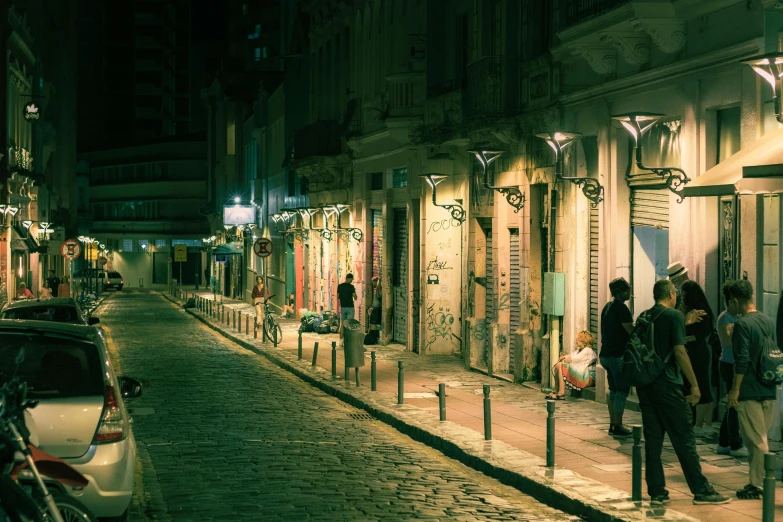 people are walking along a street at night