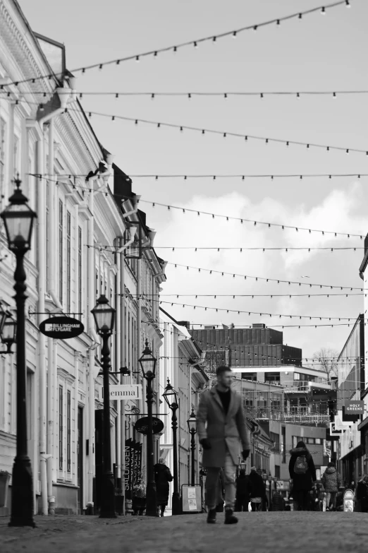 a man that is walking down the street with his luggage