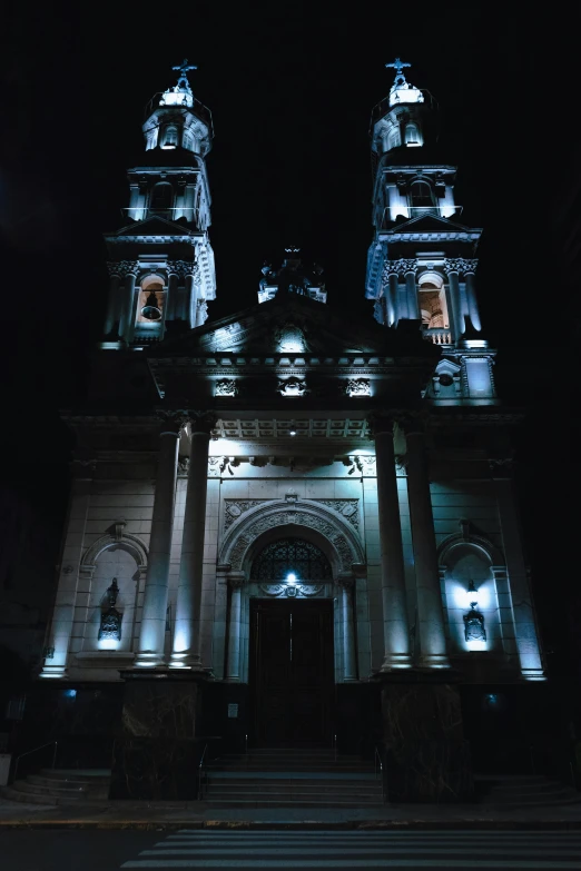 two lights shine on the building that has columns