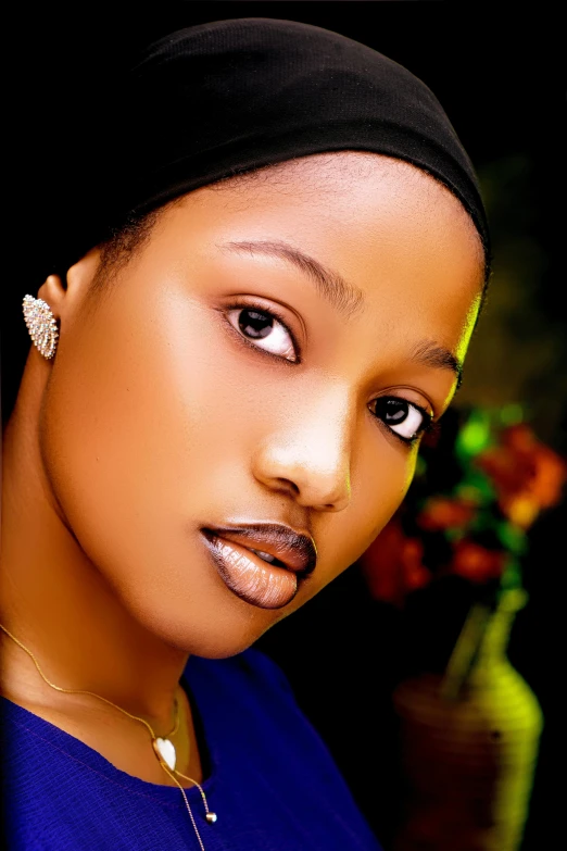 a woman poses for a pograph wearing a black headwrap