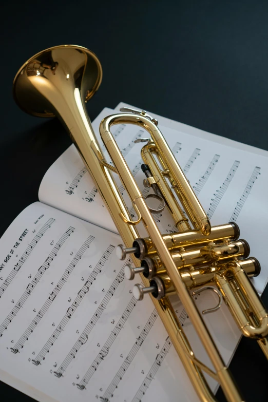 a golden trumpet sitting on top of music sheets