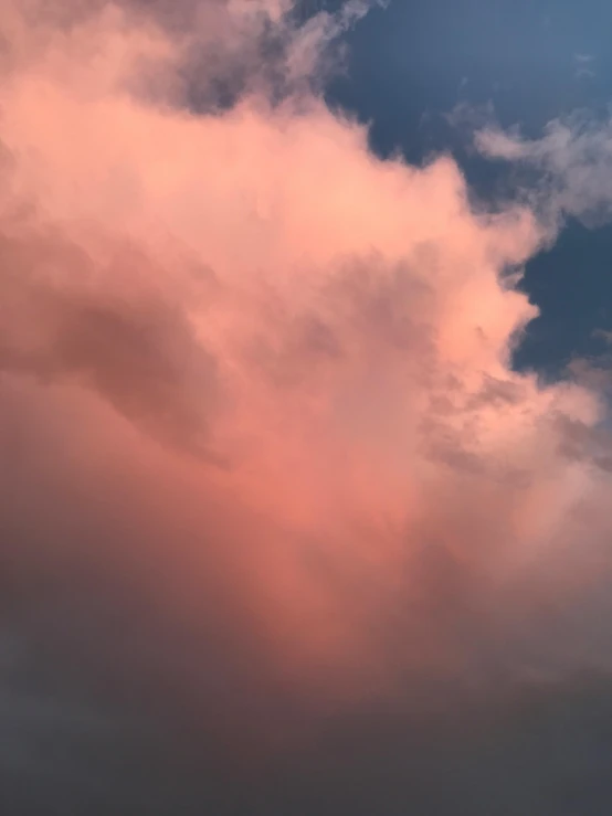 the clouds are very big and pink against blue skies