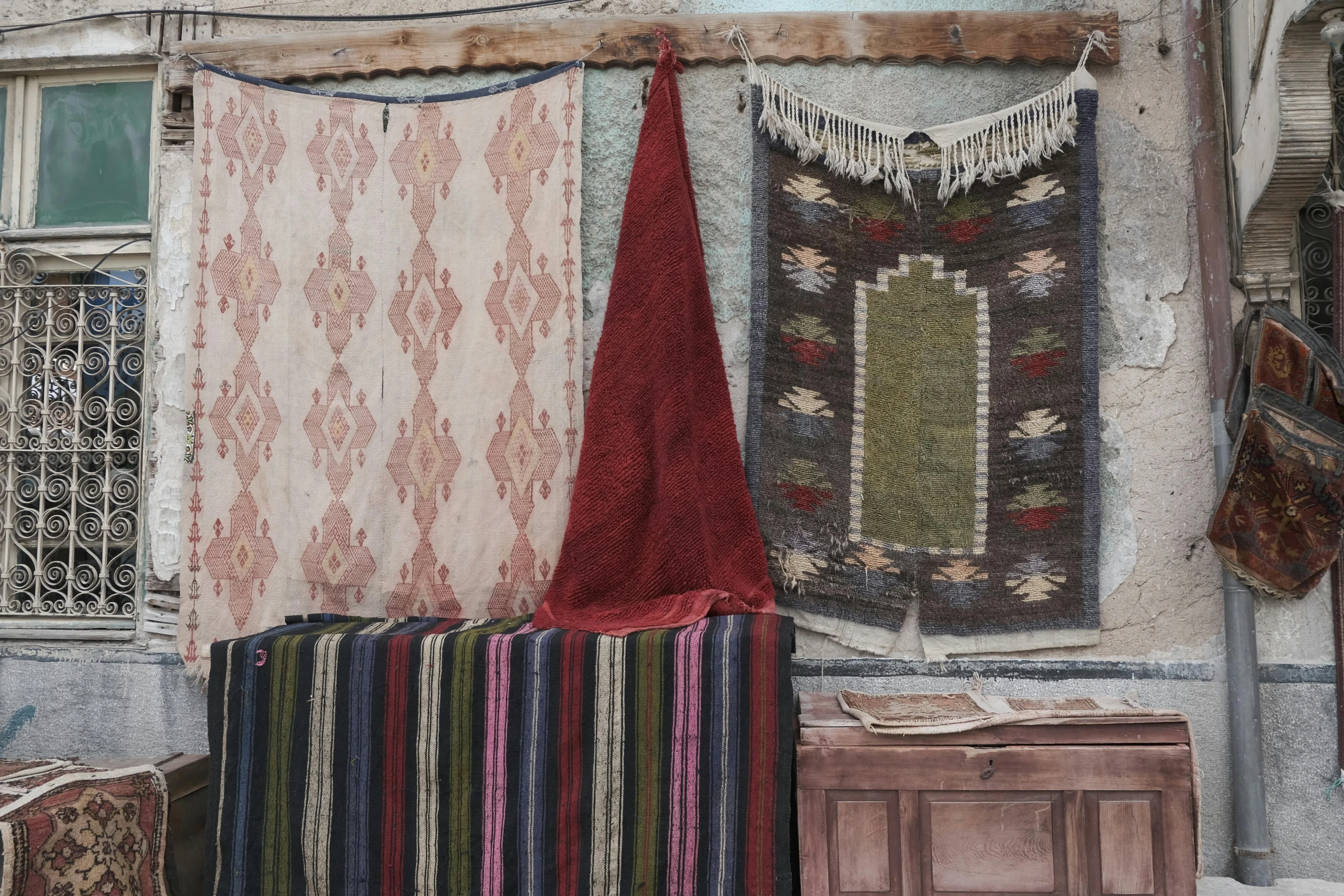 a row of knitted tapestrys are on the wall above a wooden table