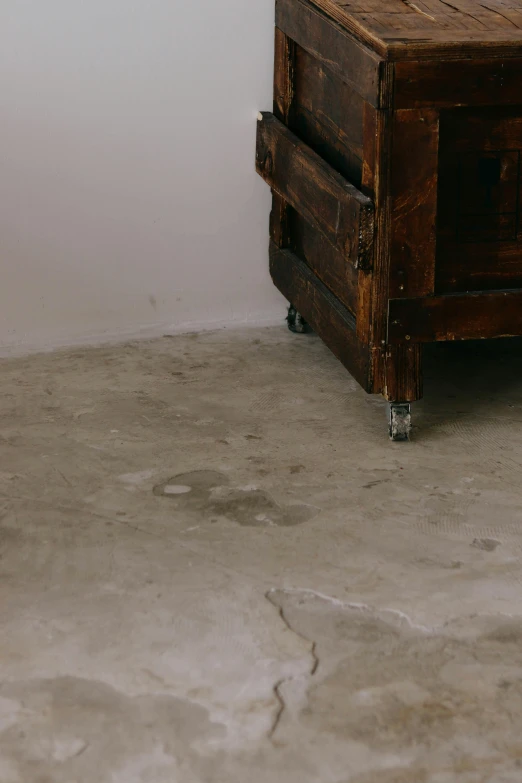 a wooden table with two drawers, placed next to a white wall