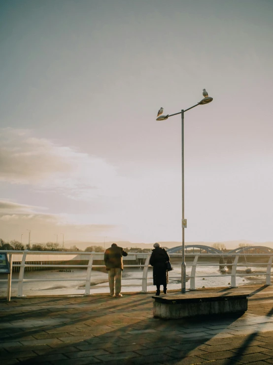 a woman is walking on the pier with her dog