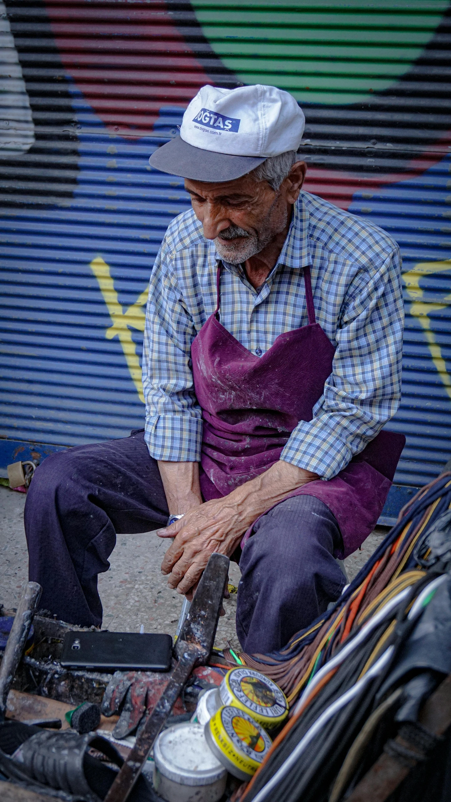 a man sitting on the ground working on his tools
