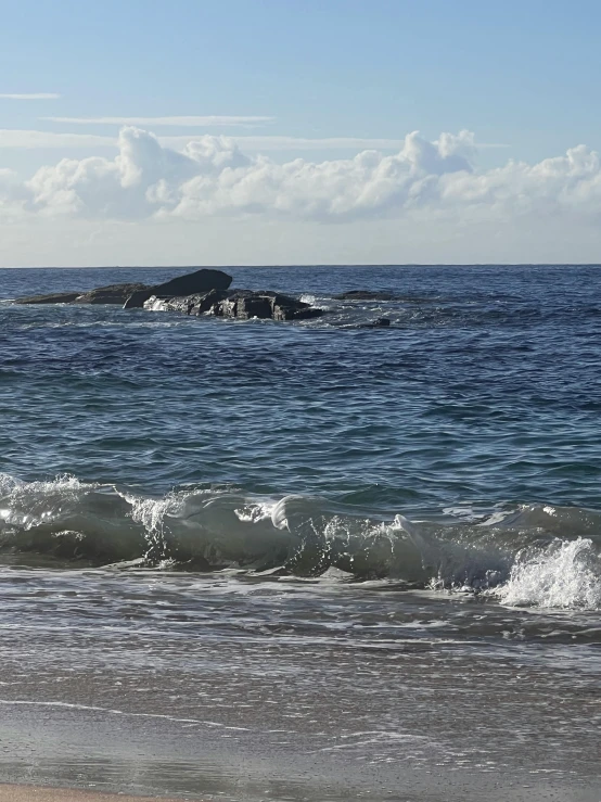 a large body of water next to a beach with waves