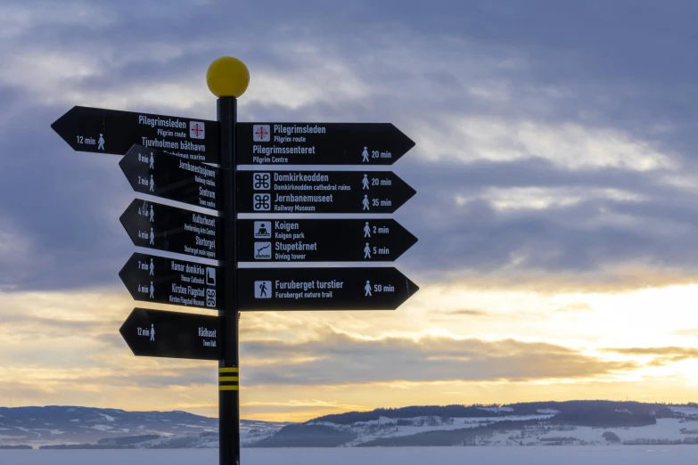 four signs on top of each other giving directions