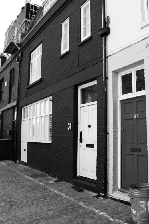 the outside of an old building with two doors and two windows