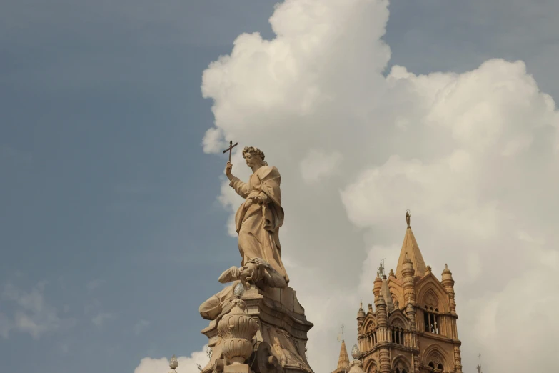 statue of jesus on the top of a steeple of a building