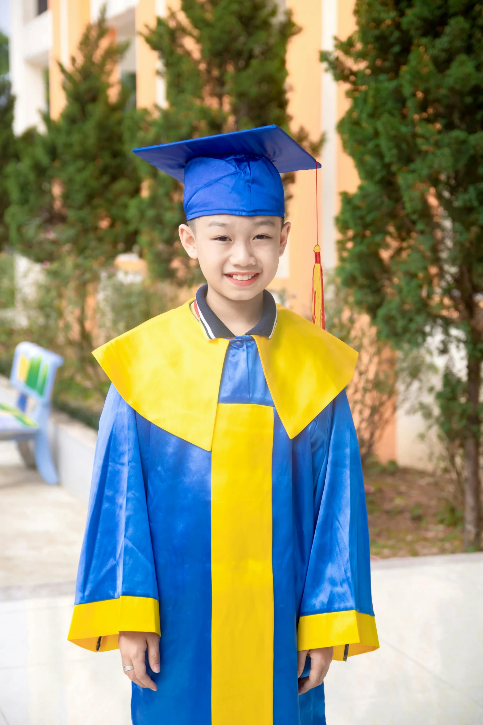 a child in graduation gown and cap is smiling