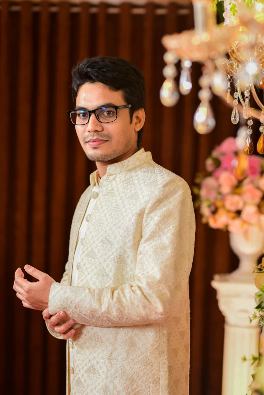 a man dressed in white wearing glasses