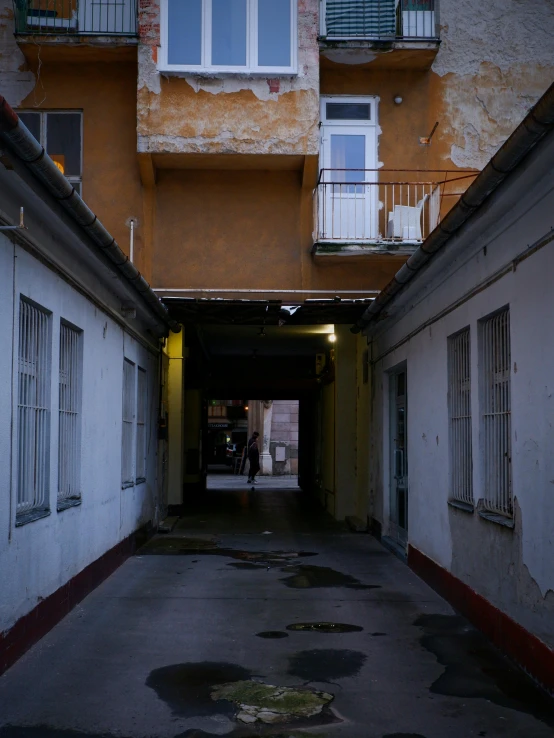 a dark hallway between two buildings with windows