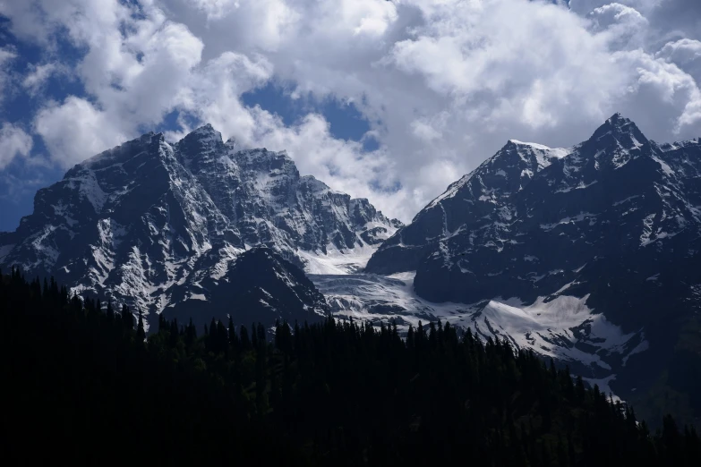 two large mountains with trees in the foreground