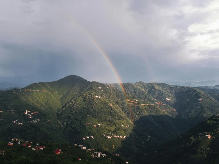 an aerial view of the mountainous region with rainbow