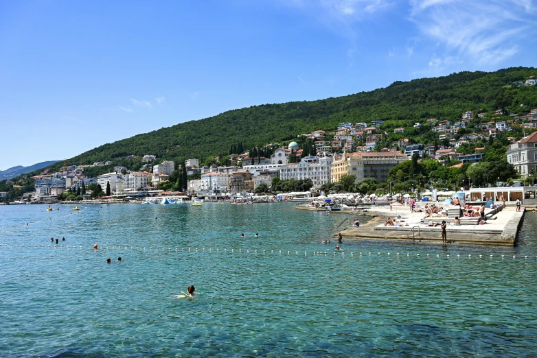 people are swimming on the water of a city bay