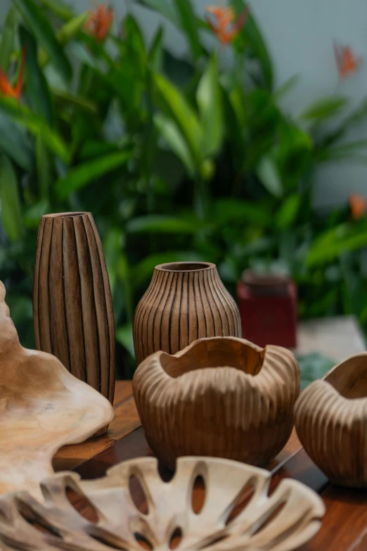 a wood table topped with carved vases and plates