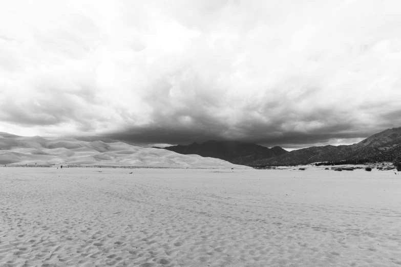 black and white po of large expanse of sand in open area