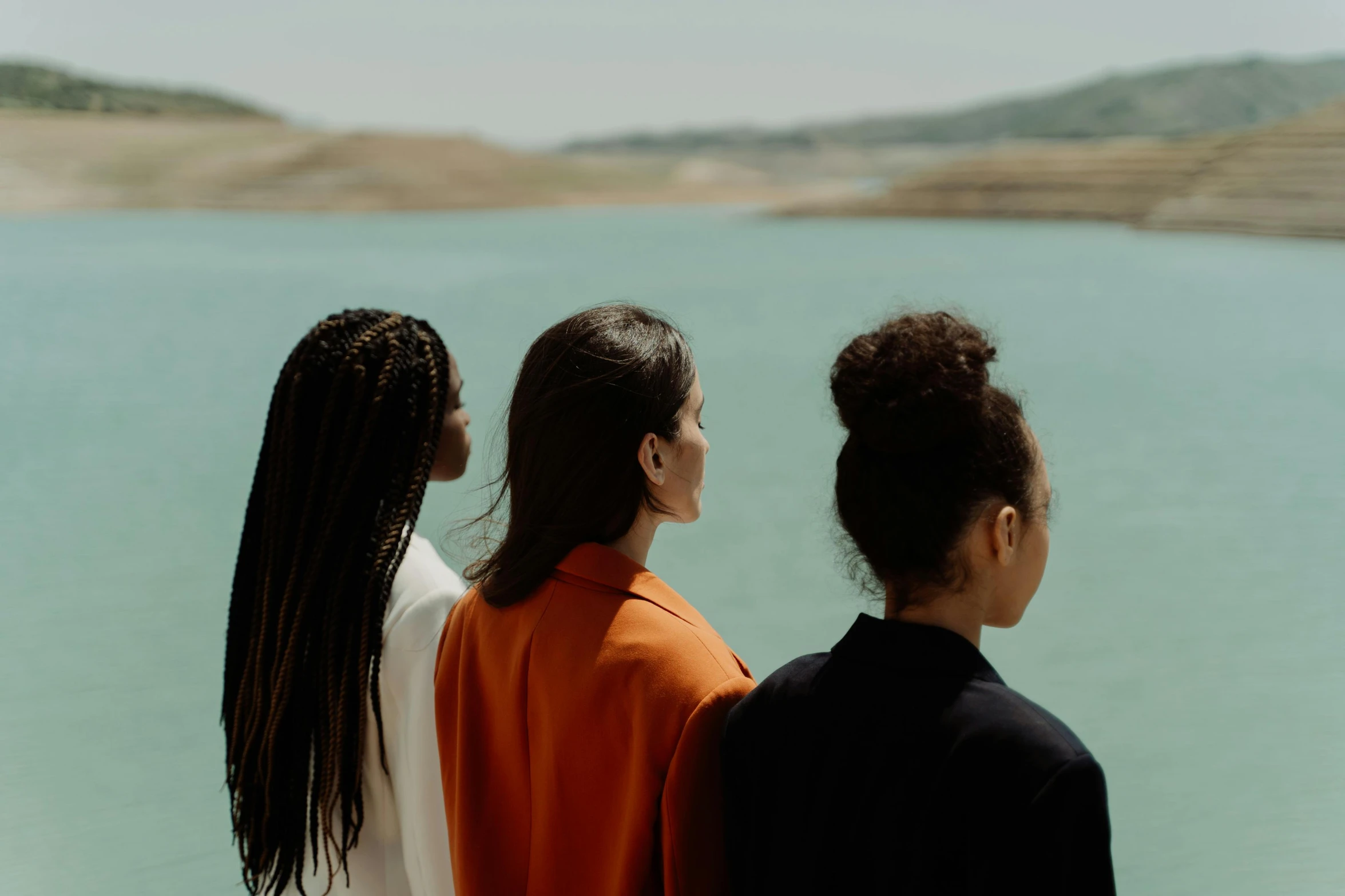 three girls looking out over the water in the sun