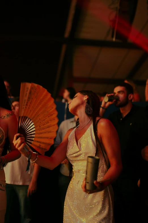 a woman in white holding a fan stands next to a man