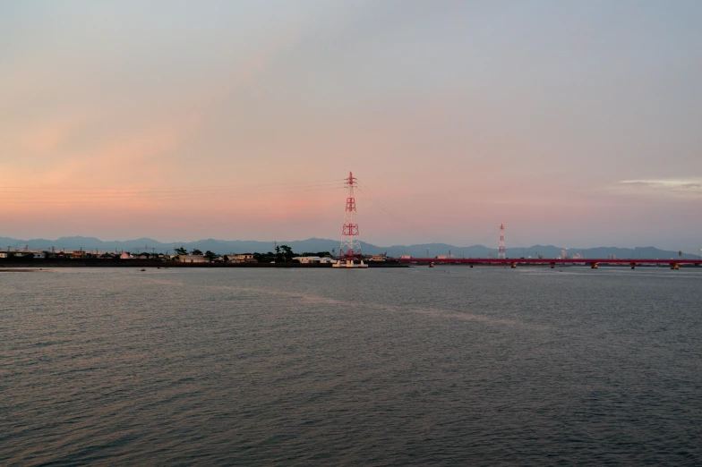 water with a bridge in the background and mountains in the background