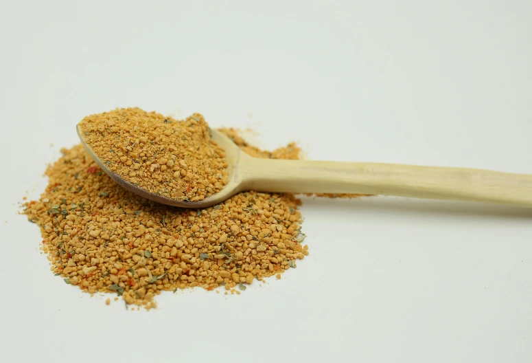 a spoon full of ground mustard sits next to an empty bag