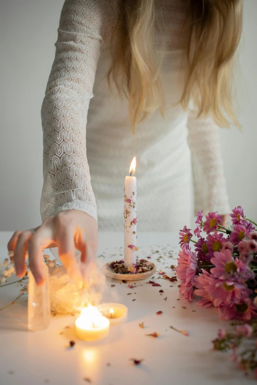 a woman kneeling in front of a lit candle