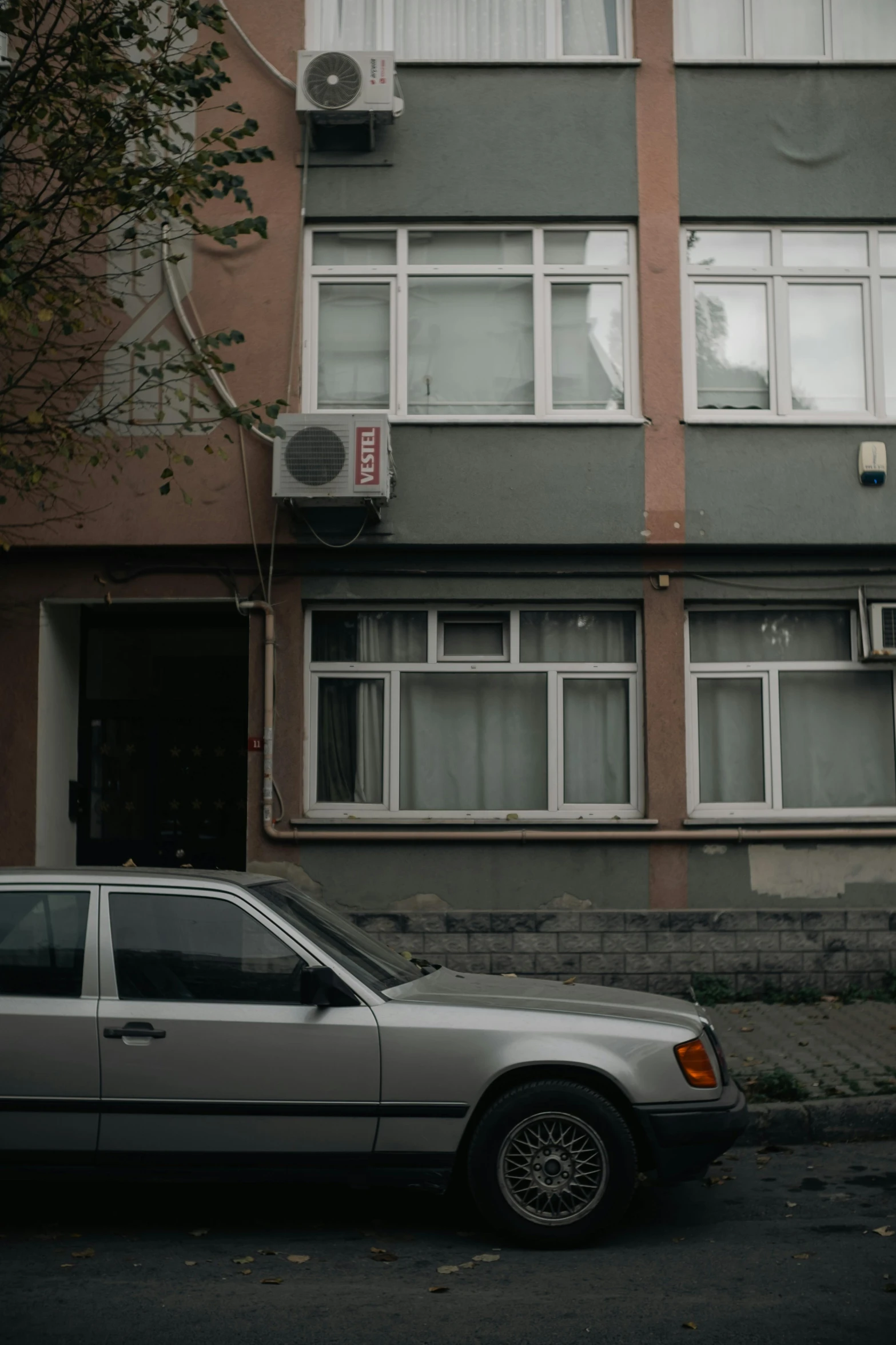 a grey station wagon parked in front of a building