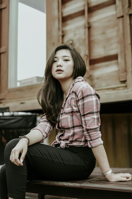 a woman sits on a bench in an outdoor setting