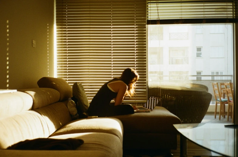 a woman sitting on a couch in front of the sun