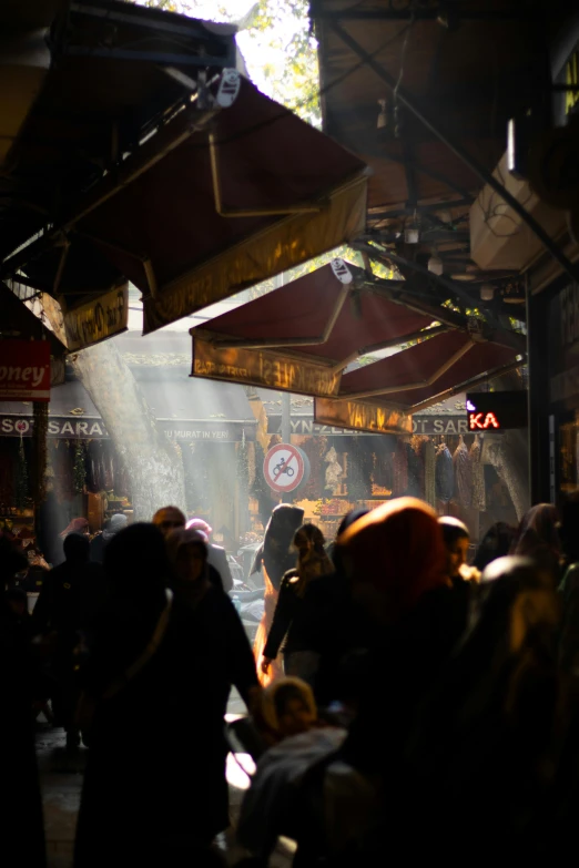 many people walk around and look at the light coming from umbrellas