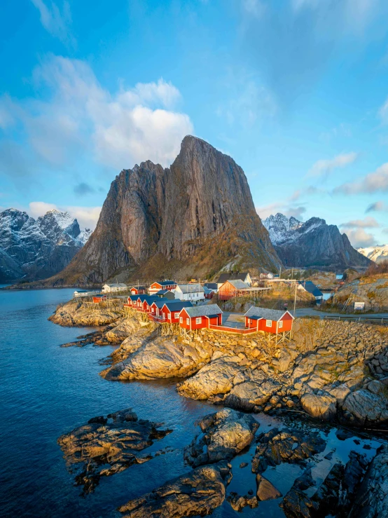 an island with mountains around it and many boats floating in the water