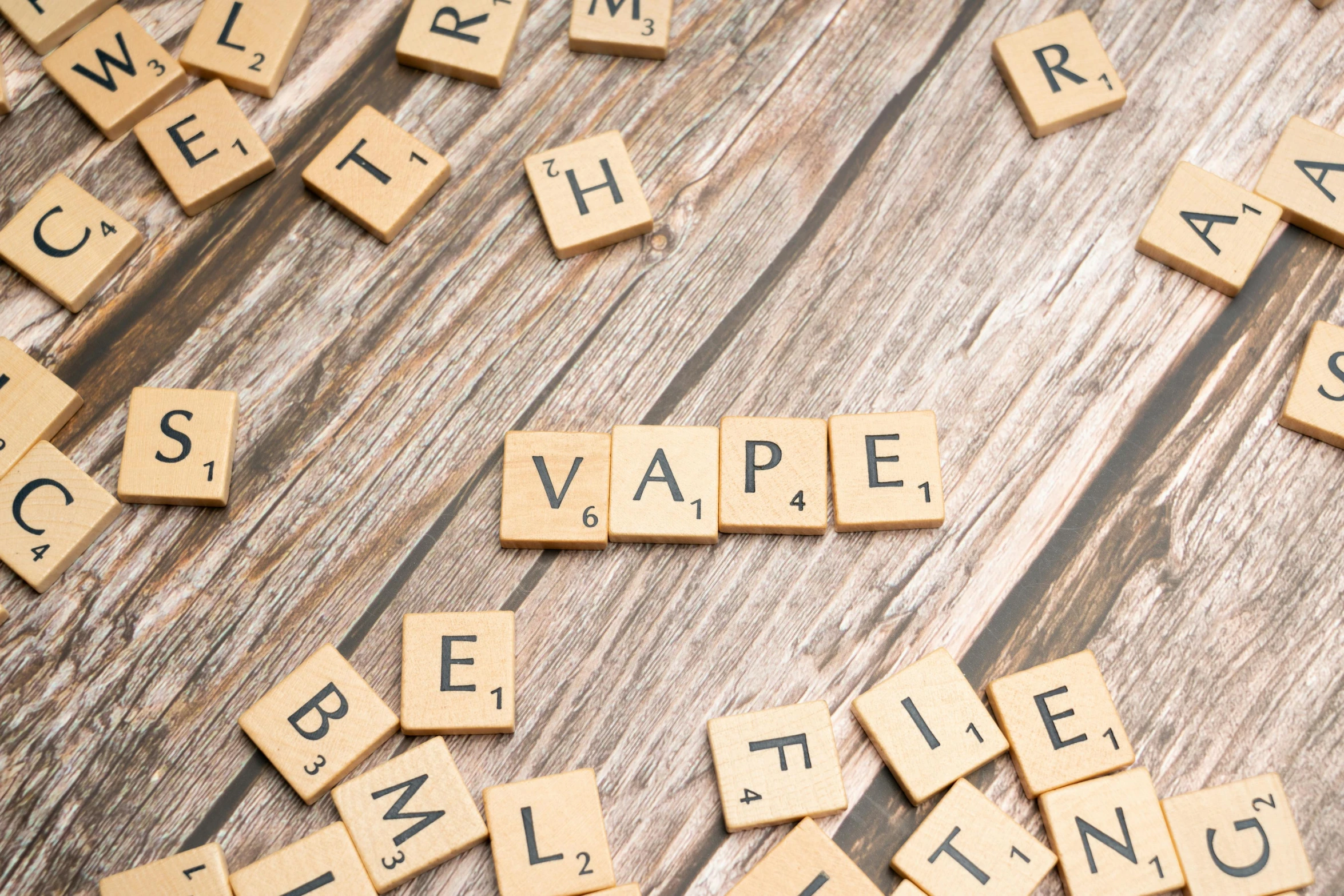 scrabbled wooden blocks spell out words on top of wood