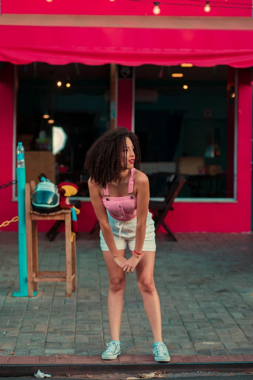 a beautiful woman standing in front of a red store