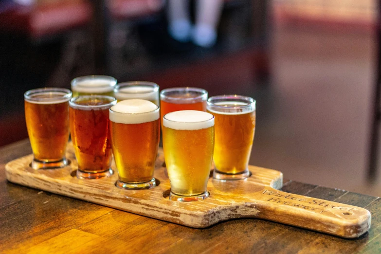 four glasses of beer sitting on a tray