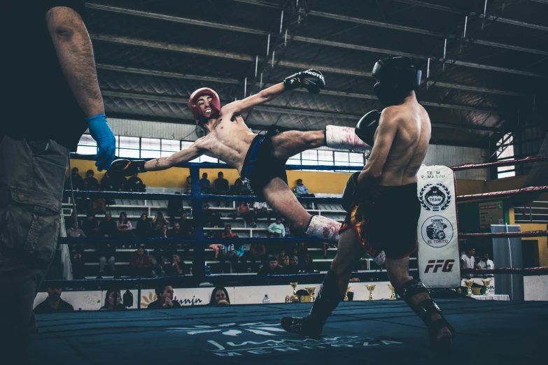 the male boxers are fighting in the ring